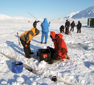 Scientists conducting remote sensing experiments on oil trapped in, and under, ice at Svea, Norway.