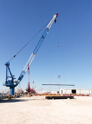 A crane prepares to load out casing on a waiting vessel at Weatherford’s nearly fully automated, casing bucking facility. The hands-free facility, which is capable of bucking casing from 41&#x2F;2 to 26 in., processed some 341,366 ft of pipe in 2014.