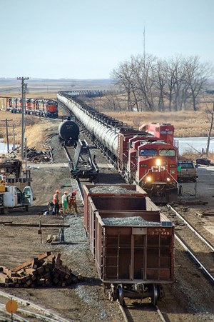 Illustrating one of DOT’s safety concerns (tank car wheels and railroad tracks), a Canadian Pacific oil train, enroute from New Town, N.D., to the East Coast, passes through Max, N.D., on Nov. 29, 2011, passing track workers who are replacing a switch. Photo by Fred W. Frailey.