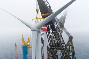offshore wind turbine being installed with a crane